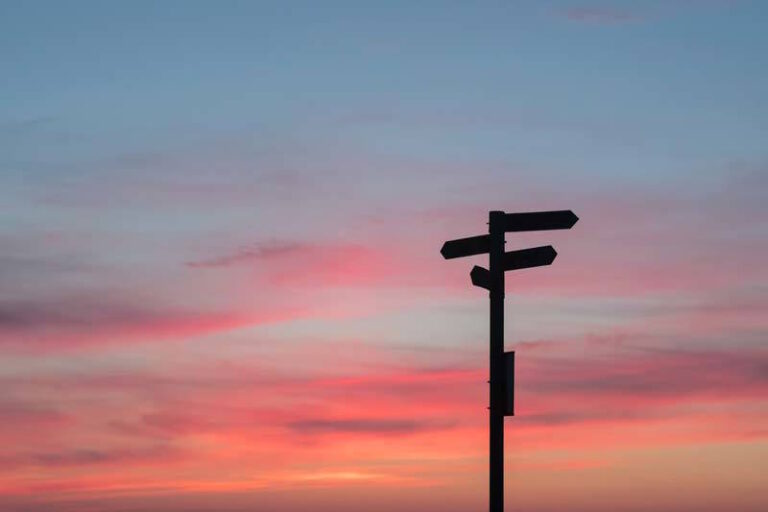 Schilder im Sonnenuntergang zeigen in verschiedene Richtungen