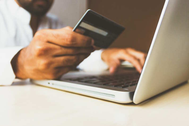 Ein Mann möchte beim Online Shopping mit Karte bezahlen