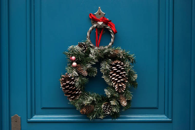 blaue weihnachtlich geschmückte Tür